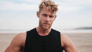 A confident young sportsman is looking to the side while training outdoors