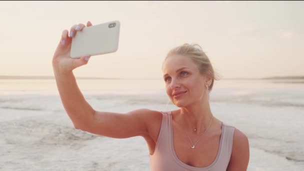 Positive Young Blonde Woman Taking Selfie Photo Using Her Smartphone — Αρχείο Βίντεο