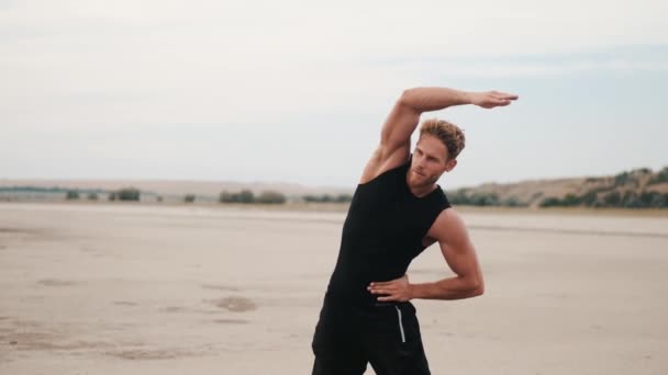 Concentrated Young Sportsman Doing Tilts While Training Outdoors — Αρχείο Βίντεο