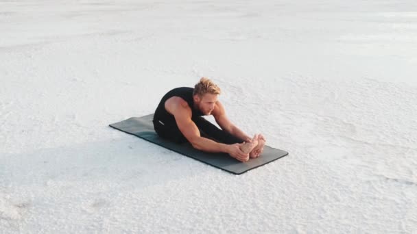 Concentrated Young Sportsman Doing Stretching Exercises While Training Outdoors Sitting — Αρχείο Βίντεο