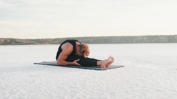 Concentrated Young Athlete Doing Stretching Exercises While Training Outdoors Sitting — Αρχείο Βίντεο