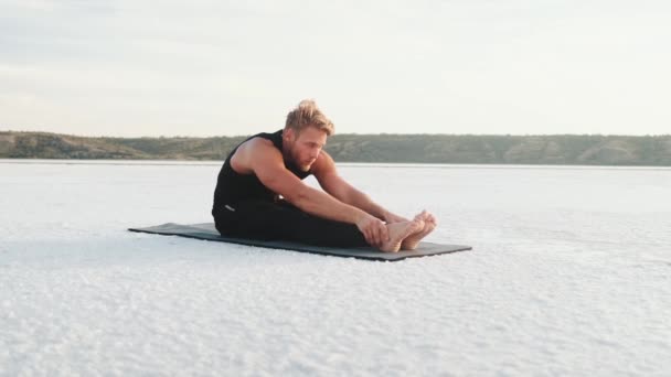 Handsome Young Athlete Doing Stretching Exercises While Training Outdoors Sitting — Vídeo de Stock