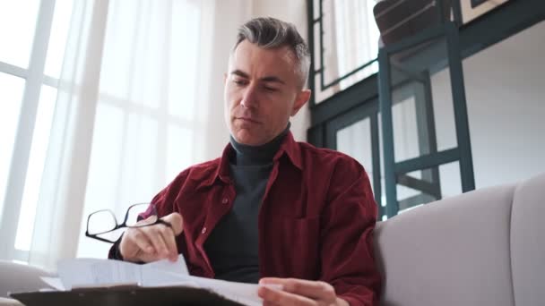 Concentrating Mature Man Holding Glasses Hands Examining Papers While Sitting — Stok video