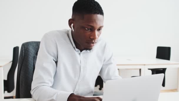 Focused Black Guy Earbuds Using His Laptop While Working Office — Stockvideo