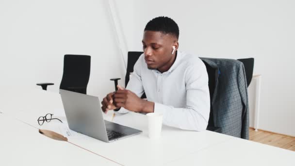 Thinking Black Guy Earbuds Using Laptop Sitting Office — Stockvideo