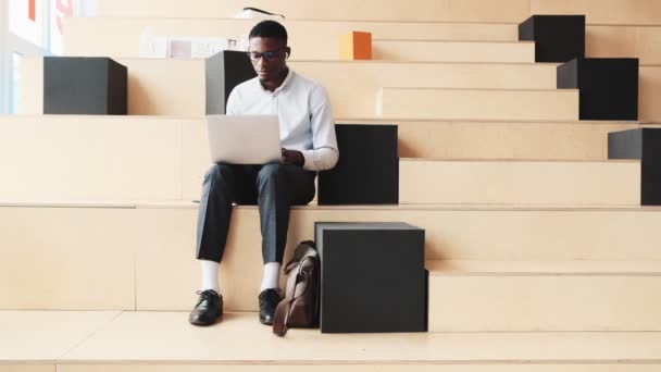 Guapo Estudiante Americano Está Usando Portátil Mientras Está Sentado Moderna — Vídeos de Stock