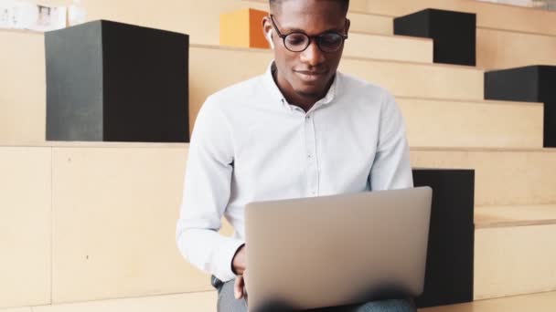 Estudiante Americano Feliz Usando Auriculares Está Escuchando Música Mientras Hace — Vídeo de stock