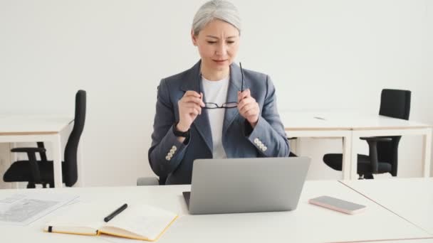 Beautiful Elder Businesswoman Putting Her Eyeglasses While Working Office — Stockvideo