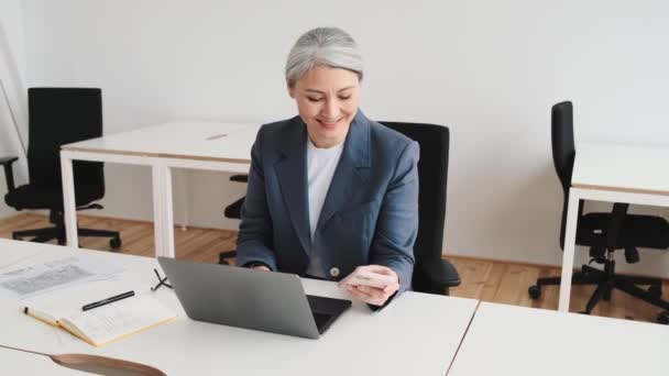 Una Anciana Empresaria Feliz Está Usando Teléfono Inteligente Mientras Trabaja — Vídeos de Stock