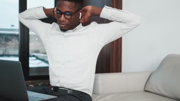 이어폰을 집약적 아프리카 미국인 사업가 아파트 에등을 늘이면서 자신의 노트북 — 비디오