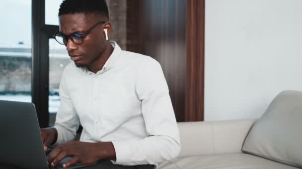Hombre Negocios Afroamericano Concentrado Usando Auriculares Está Usando Computadora Portátil — Vídeos de Stock