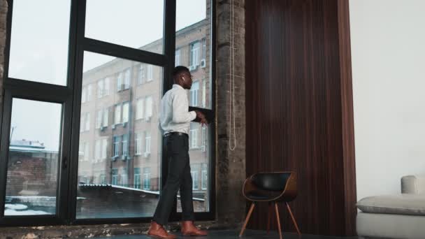 Ein Seriöser Afrikanisch Amerikanischer Geschäftsmann Der Ohrhörer Trägt Spricht Dachgeschoss — Stockvideo