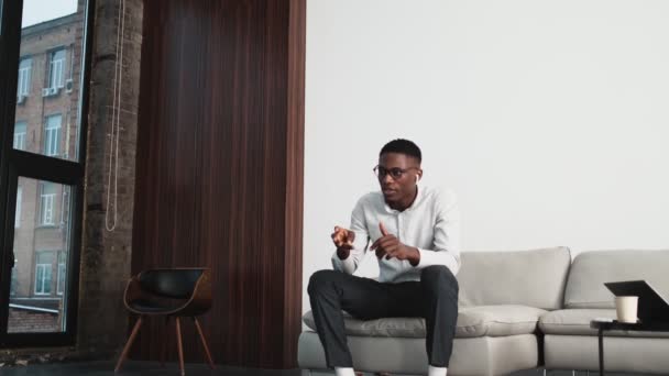 Handsome African American Businessman Wearing Wireless Earphones Talking Sitting Loft — Stock videók