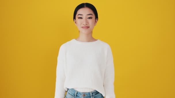 Happy Asian Woman Doing Gesture Standing Isolated Yellow Wall Studio — Stock Video