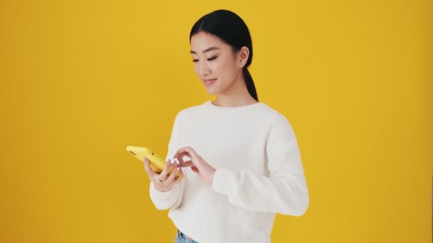 Leende Asiatisk Kvinna Sveper Sin Smartphone Och Visar Tummen Upp — Stockvideo