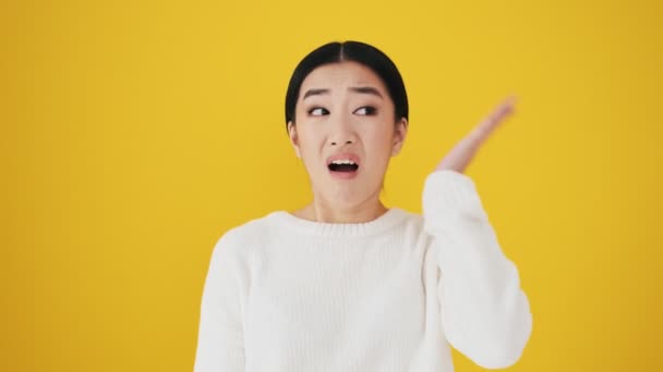 Confused Asian Woman Touching Her Head Standing Isolated Yellow Wall — Stock Video