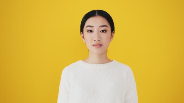 Confused Asian Woman Covering Her Mouth Standing Isolated Yellow Wall — Stock Video