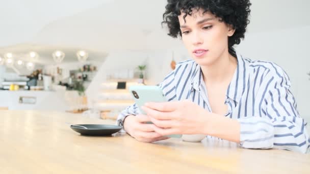 Una Mujer Positiva Está Usando Teléfono Inteligente Mientras Está Sentada — Vídeo de stock