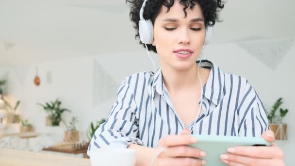 Una Mujer Feliz Con Auriculares Está Escuchando Música Mirando Teléfono — Vídeo de stock