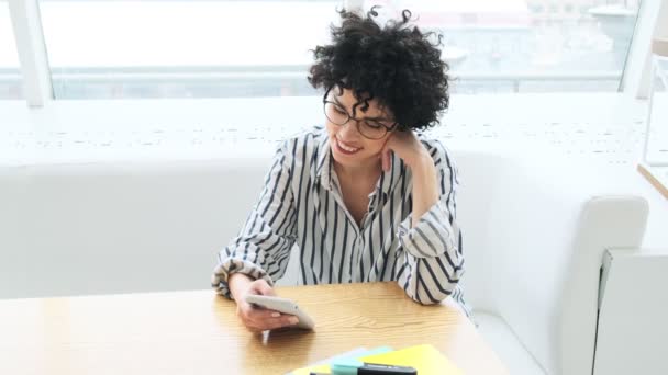 Kafede Oturan Mutlu Bir Kadın Akıllı Telefonunu Kullanıyor — Stok video