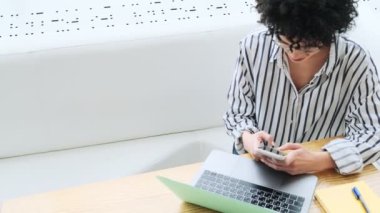 Bir kadının en iyi görüntüsü, kafede dizüstü bilgisayarıyla çalışırken akıllı telefon kullanmasıdır.