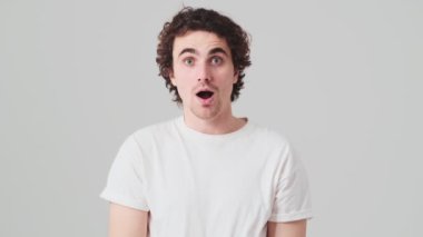 The surprised man pressing his lip and shaking his head while standing in the studio