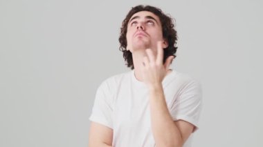 The surprised man in search of something looking around and gesturing with his hands in the studio