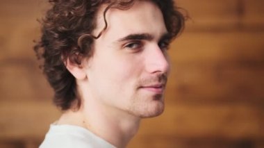 The side-view of smiling man showing okay while standing in the wooden studio