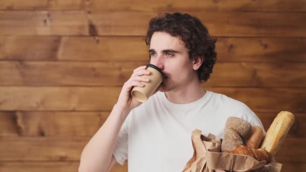 Задумчивый Человек Хлебом Чашкой Руках Наслаждается Вкусом Пьяного Смотрящего Камеру — стоковое видео