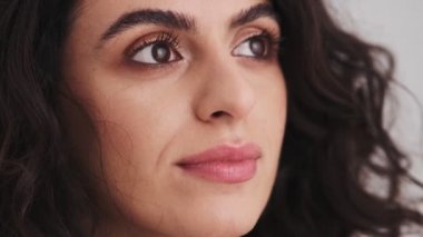 A close-up view of a smiling woman's face looking to the side