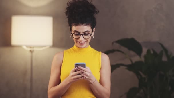 Mujer Riendo Con Gafas Mirando Teléfono Pensando Qué Escribir Respuesta — Vídeos de Stock