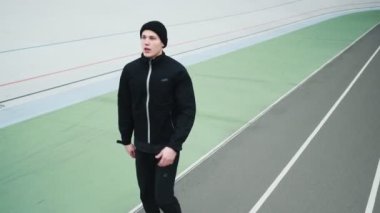 Sağlıklı genç bir sporcu stadyumda ısınma egzersizleri yaparken maraton koşmadan önce hazırlanıyor.