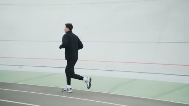 Stadyumda Kulaklık Takan Genç Bir Sporcunun Yan Görüntüsü Koşuyor — Stok video