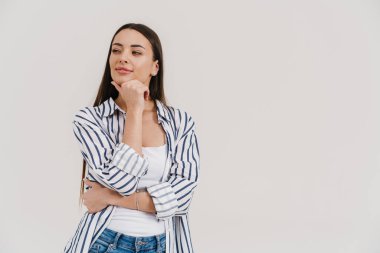 Mutlu düşünen esmer kız gülümsüyor ve beyaz arka planda tek başına bir kenara bakıyor.