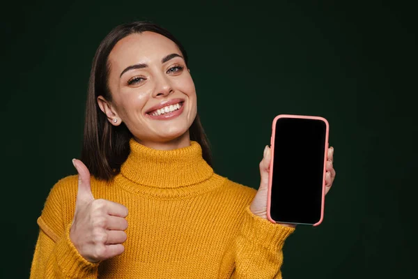 快乐美丽的女孩在绿色背景下展示手机和大拇指 — 图库照片