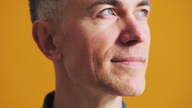 Stüdyoda gülümseyen olgun bir adamın yakın plan fotoğrafı.