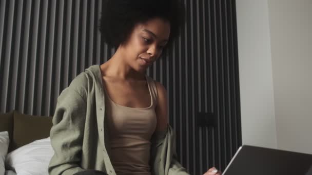 Black Smiling Woman Looking Laptop Holding Her Feet While Sitting — Stockvideo