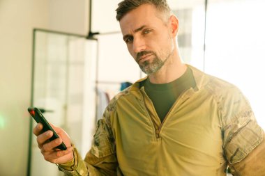 İçeride cep telefonu kullanan kendinden emin, erkeksi bir asker.