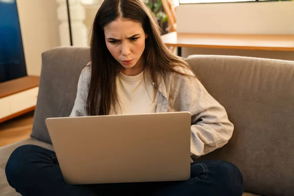 Mujer Joven Concentrada Que Trabaja Con Ordenador Portátil Mientras Está — Foto de Stock
