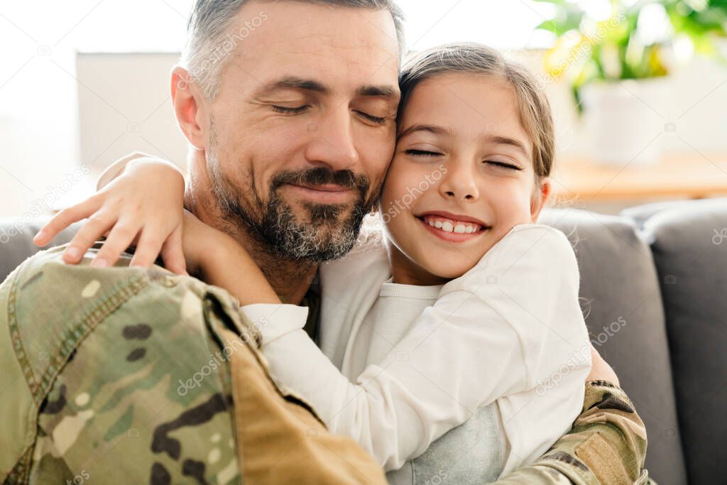 Happy military father and his daughter reunion at home. Family reunion or returning home concept