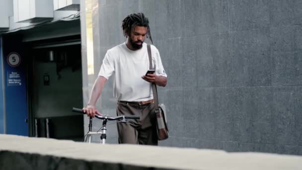 Een Gefocuste Afro Amerikaanse Man Gebruikt Zijn Smartphone Tijdens Het — Stockvideo