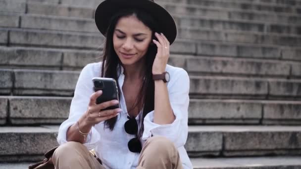 Una Hermosa Mujer Con Sombrero Está Usando Teléfono Móvil Sentado — Vídeos de Stock