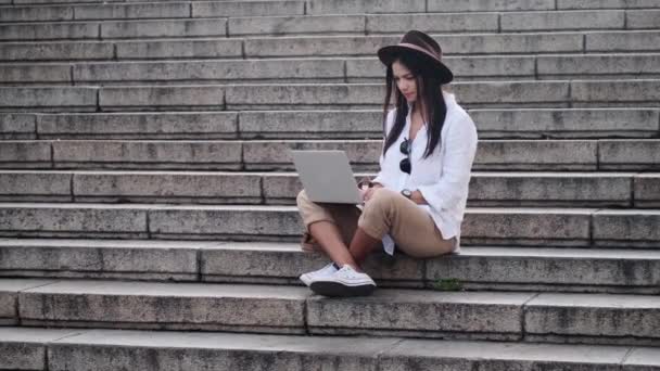 Una Joven Tranquila Con Sombrero Está Usando Computadora Portátil Sentada — Vídeos de Stock