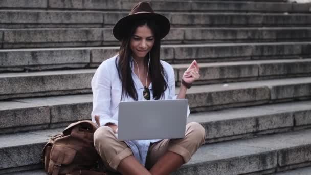 Szczęśliwa Młoda Kobieta Kapeluszu Słucha Muzyki Pomocą Laptopa Siedząc Latem — Wideo stockowe