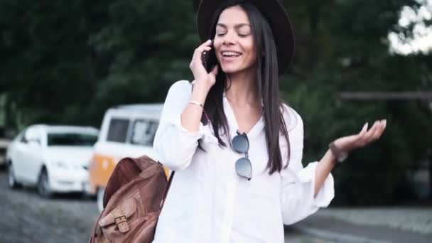 Щаслива Молода Жінка Говорить Своєму Смартфоні Під Час Прогулянки Вулиці — стокове відео