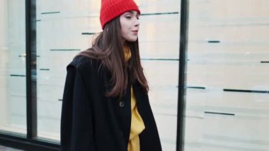 Paltolu ve şapkalı bir kadın sokakta yürüyor.