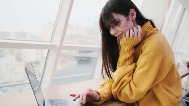 Mujer Sonriente Hojeando Algo Portátil Mientras Está Pie Frente Ventana — Vídeos de Stock