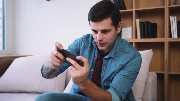 Ein Emotionaler Mann Spielt Auf Seinem Smartphone Während Auf Dem — Stockvideo