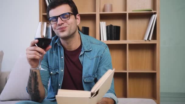 Hombre Guapo Con Gafas Está Bebiendo Una Copa Vino Mientras — Vídeo de stock