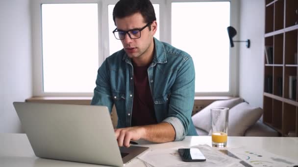 Ein Seriöser Mann Mit Brille Sitzt Morgens Mit Seinem Laptop — Stockvideo